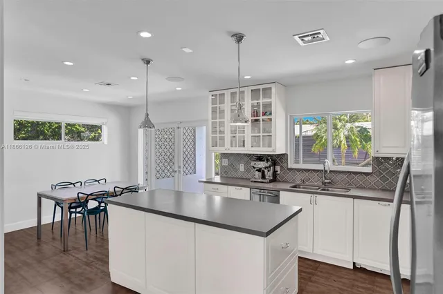 a kitchen with granite countertop a sink a center island a stove and a window
