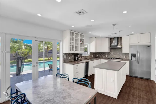 a kitchen with a sink a counter top space a large window and stainless steel appliances