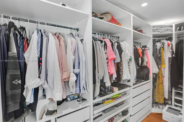 a view of walk in closet with clothes