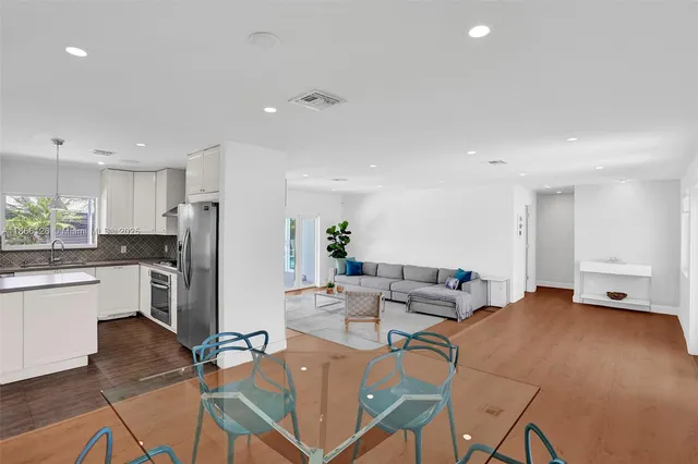 a living room with furniture and a refrigerator