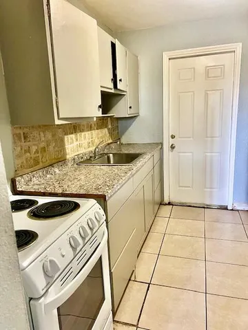 a kitchen with a stove a sink and a microwave
