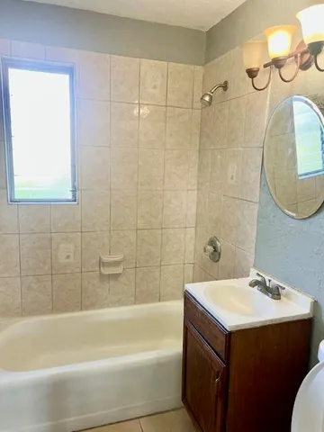 a bathroom with a sink mirror toilet and bathtub