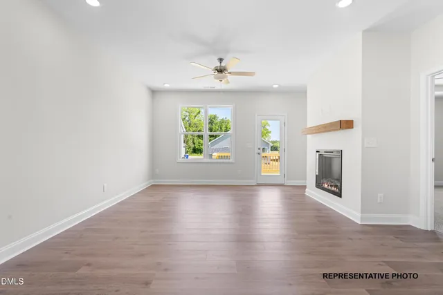an empty room with wooden floor a ceiling fan and a window