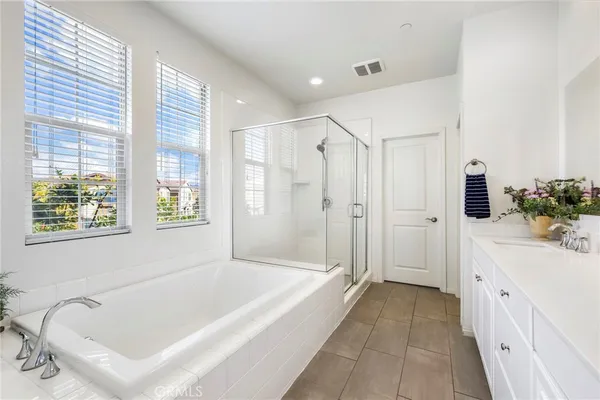 a bathroom with a tub a sink a mirror and a shower
