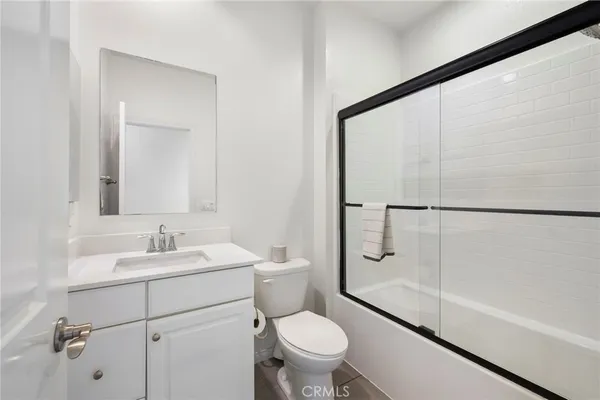 a bathroom with a granite countertop toilet sink and shower