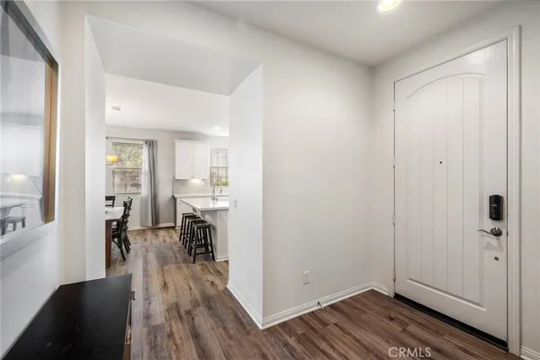 a view of a livingroom with wooden floor and a kitchen