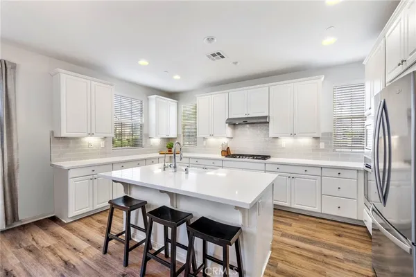 a kitchen with stainless steel appliances granite countertop a white cabinets and wooden floor