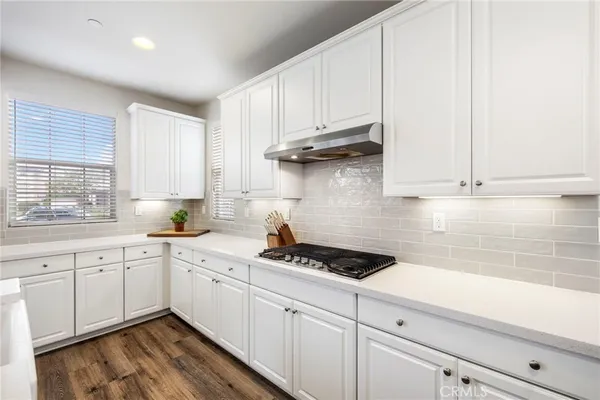 a kitchen with stainless steel appliances granite countertop white cabinets a sink and dishwasher