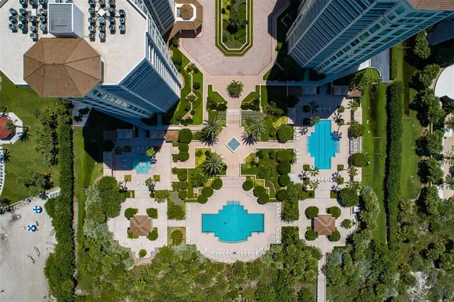 a front view of multi story residential apartment building with yard and sign board