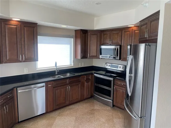 a kitchen with granite countertop a sink and cabinets