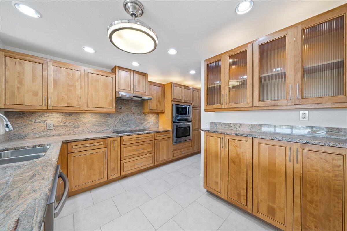 2220 Front Street, Unit 402 Melbourne, FL 32901 - Photo 11 of 26 a kitchen with stainless steel appliances granite countertop a stove a sink and a microwave