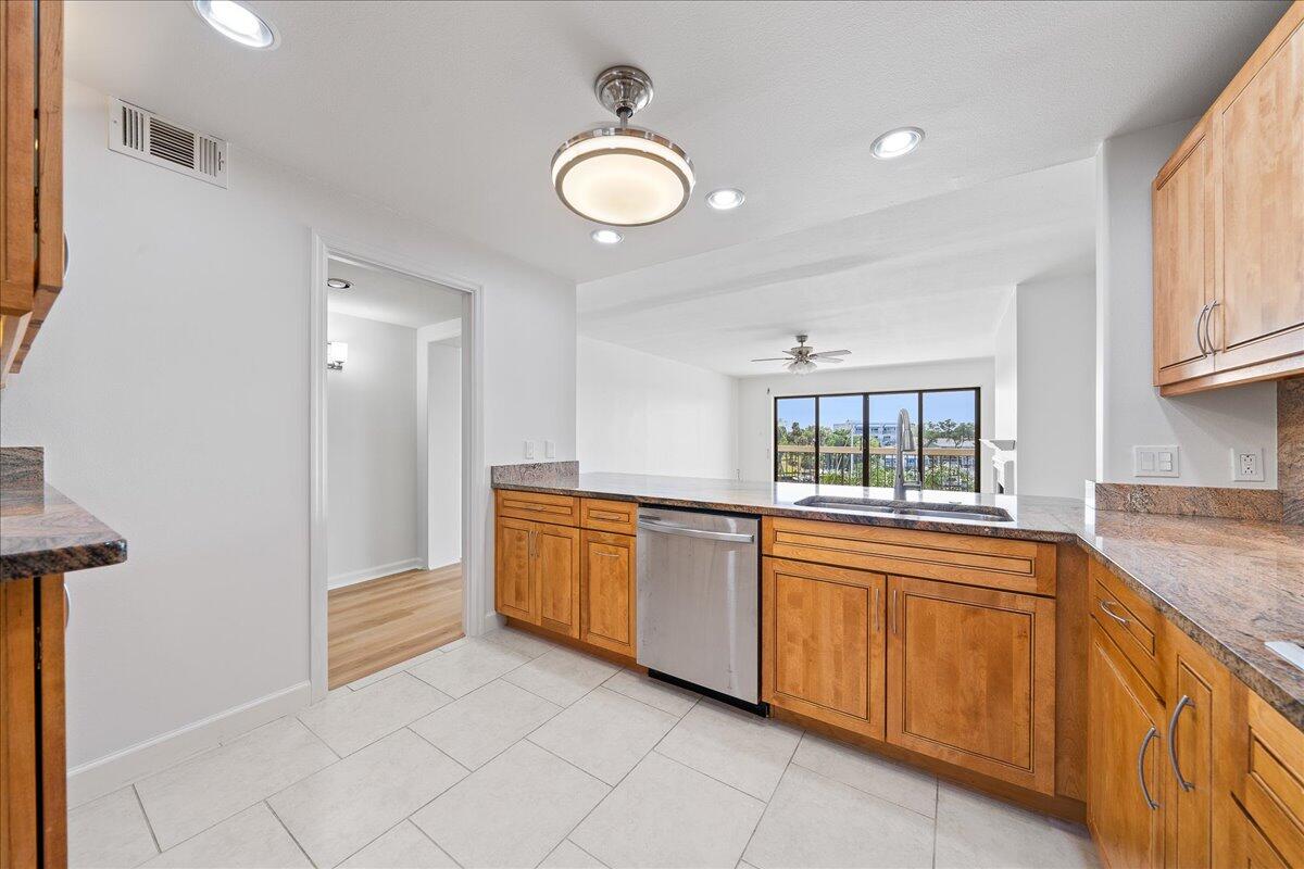 2220 Front Street, Unit 402 Melbourne, FL 32901 - Photo 10 of 26 a kitchen with granite countertop white cabinets and stainless steel appliances
