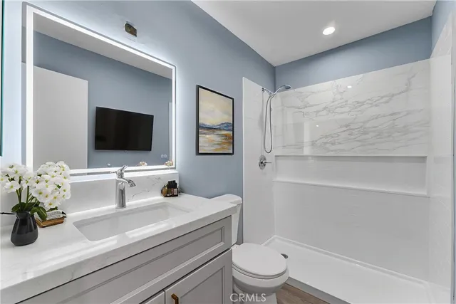 a bathroom with a toilet a sink and mirror