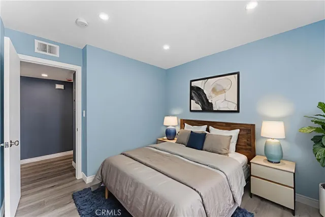 a bedroom with a bed and painting on the wall