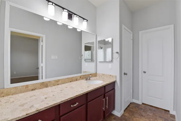 a bathroom with a granite countertop sink and a mirror
