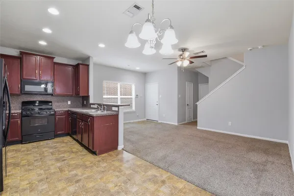 a large kitchen with stainless steel appliances granite countertop a stove oven a sink dishwasher with a dining table and chairs