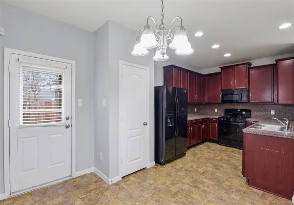 a kitchen with stainless steel appliances granite countertop a refrigerator and a stove top oven
