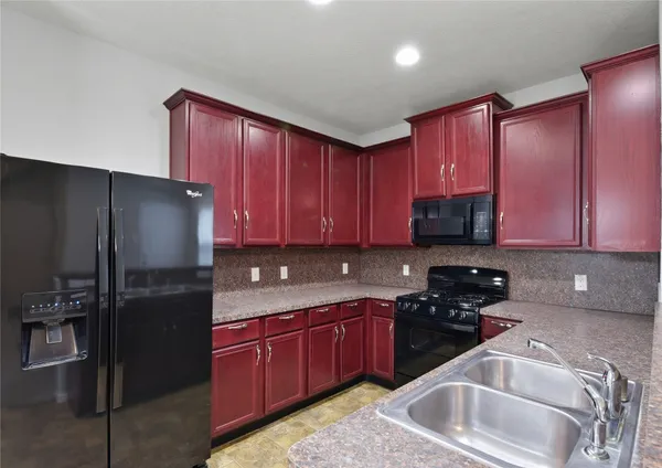 a kitchen with a refrigerator sink and cabinets