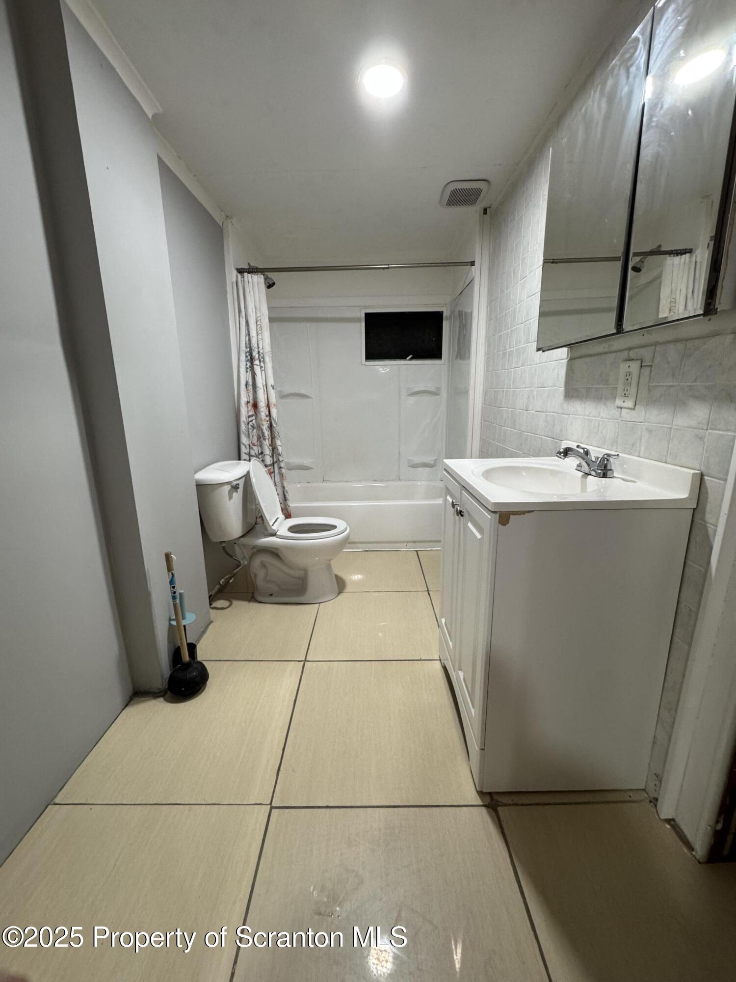 618 Deacon Street Scranton, PA 18509 - Photo 11 of 12 a bathroom with a sink a toilet and mirror