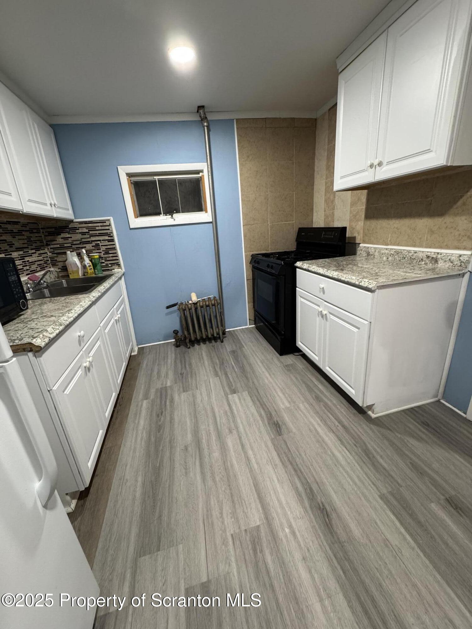 618 Deacon Street Scranton, PA 18509 - Photo 2 of 12 a kitchen with wooden floors and white appliances
