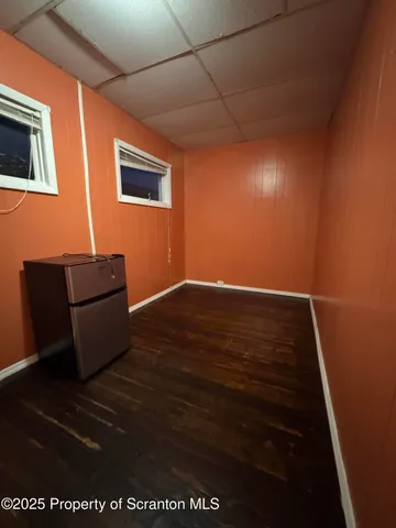 a view of room with wooden floor and black cabinet