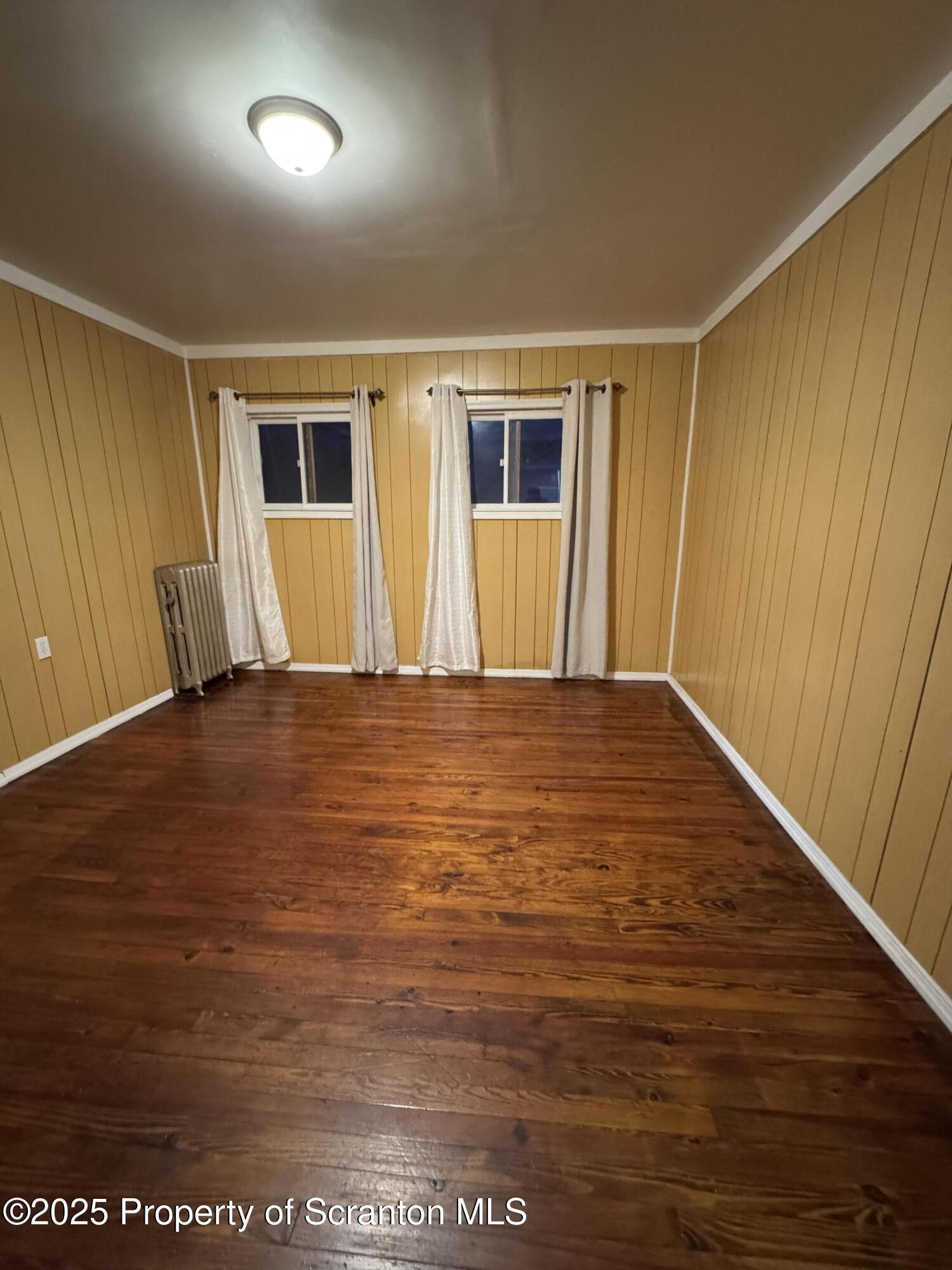 618 Deacon Street Scranton, PA 18509 - Photo 9 of 12 a view of an empty room with wooden floor and a window