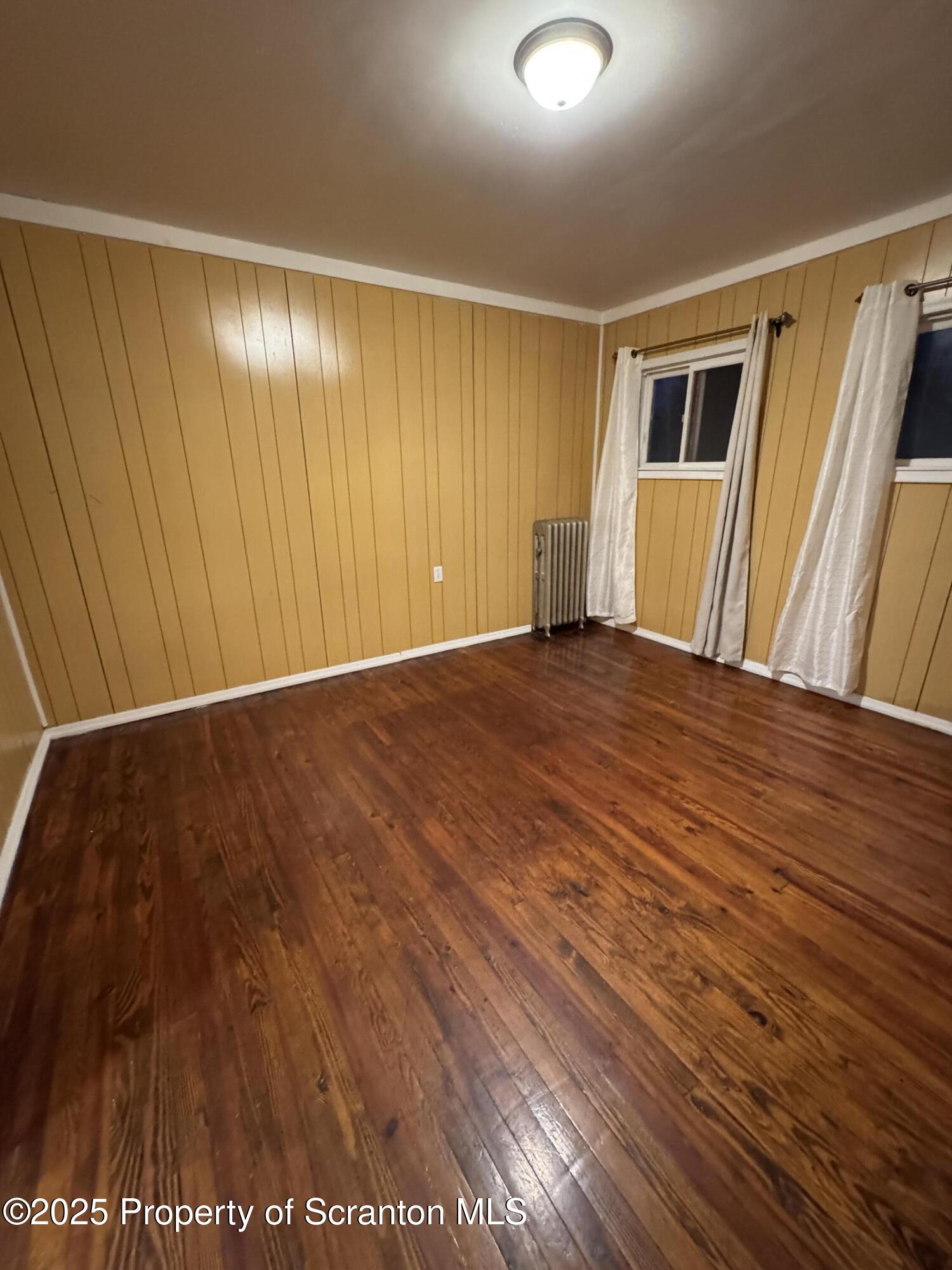 618 Deacon Street Scranton, PA 18509 - Photo 10 of 12 a view of an empty room with wooden floor and a window