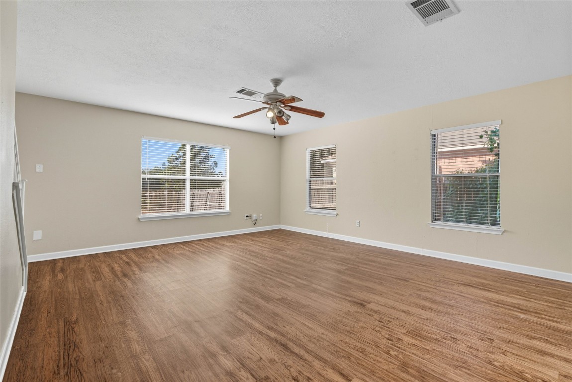 3621 Walleye Way Round Rock, TX 78665 - Photo 5 of 14 Spare room featuring dark wood-style floors, plenty of natural light, and a ceiling fan