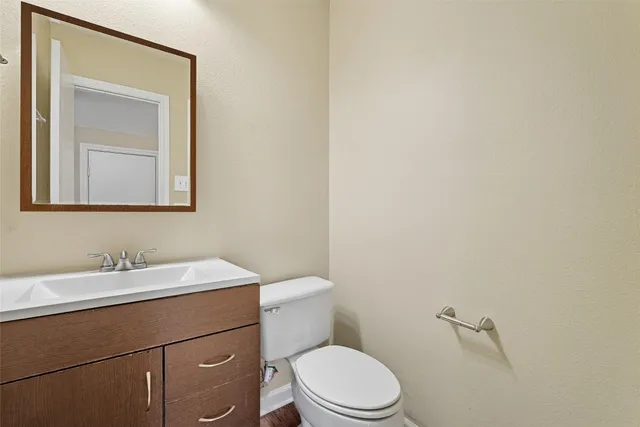 a bathroom with a toilet a sink and mirror