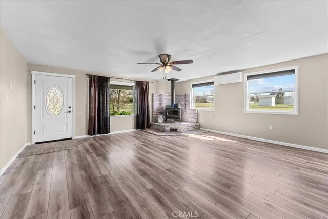 a view of an empty room with window and wooden floor