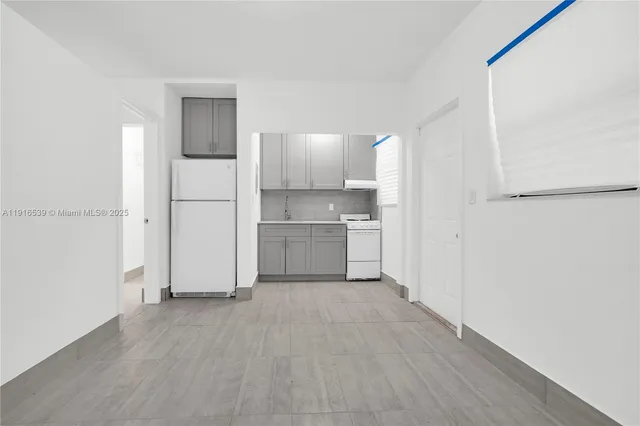 a view of a kitchen with a sink and a refrigerator