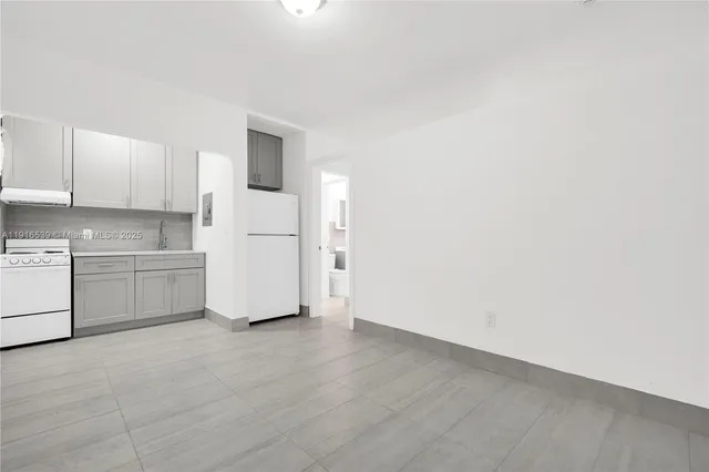 a view of a kitchen with white cabinets and white appliances