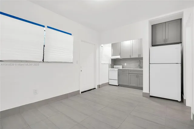 a view of a kitchen with a sink and a refrigerator