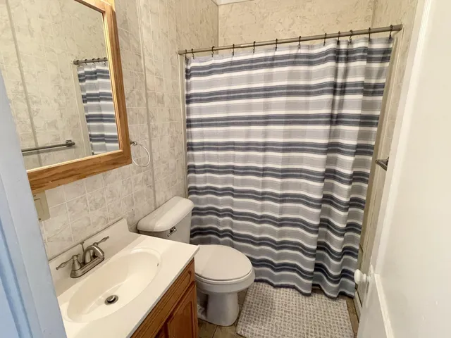 a bathroom with a sink a toilet and shower curtain