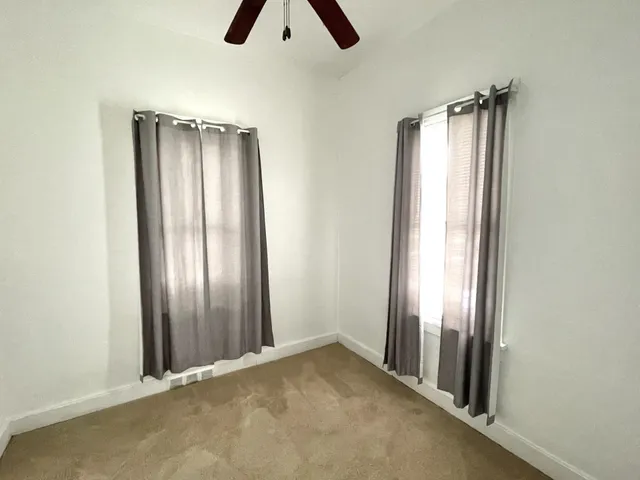 an empty room with closet and windows