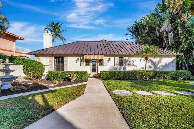 a view of a white house with a yard and plants