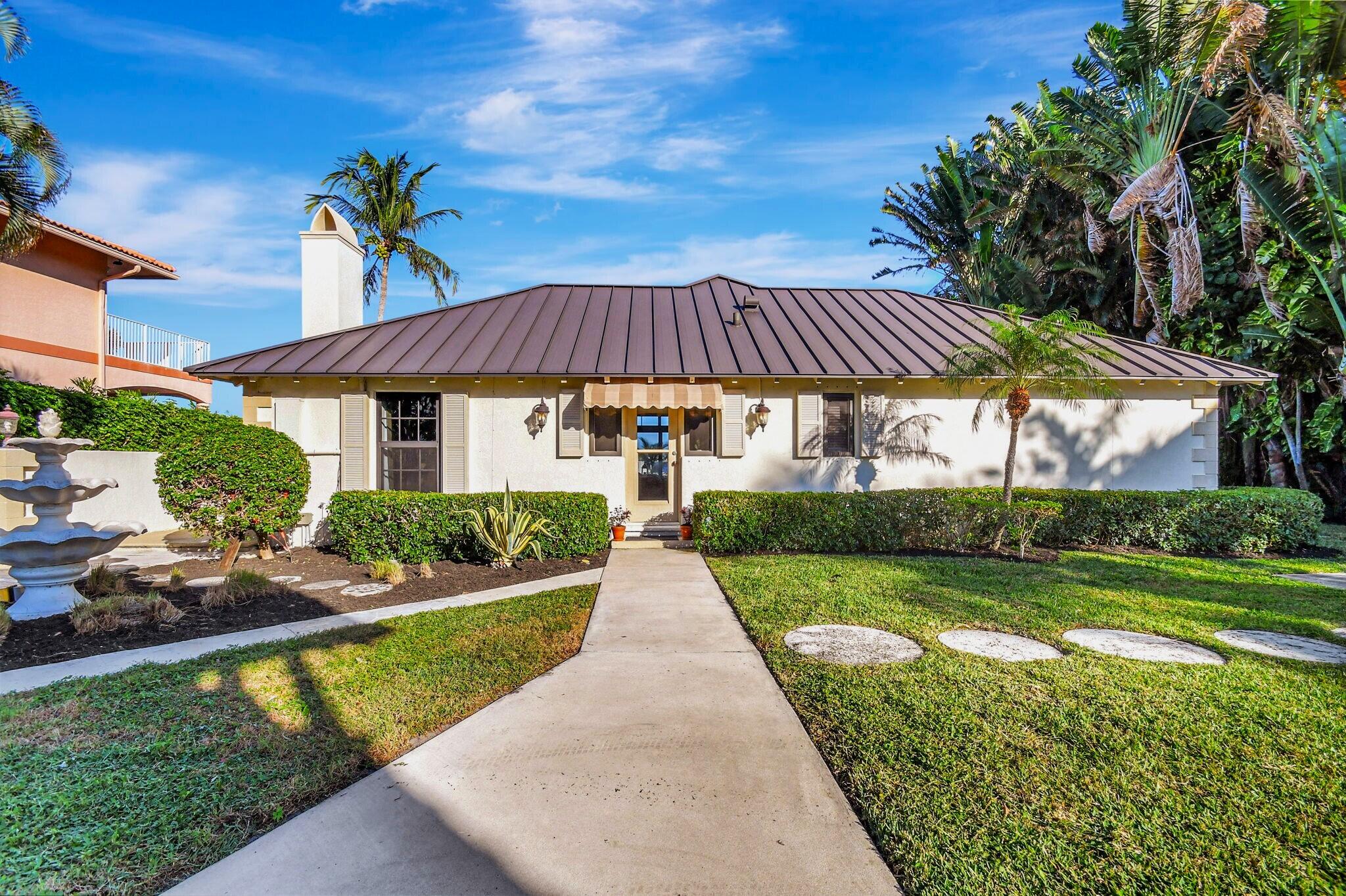 310 South Lake Drive Lantana, FL 33462 - Photo 11 of 65 a front view of a house with a yard