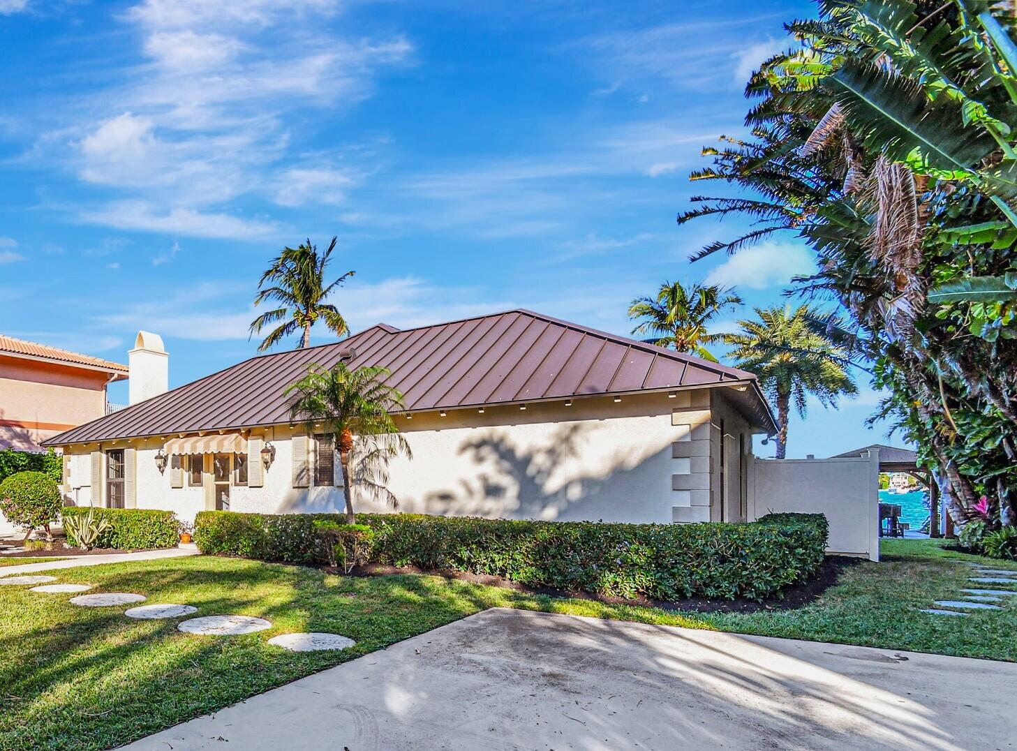 310 South Lake Drive Lantana, FL 33462 - Photo 13 of 65 a view of a white house with a yard and plants
