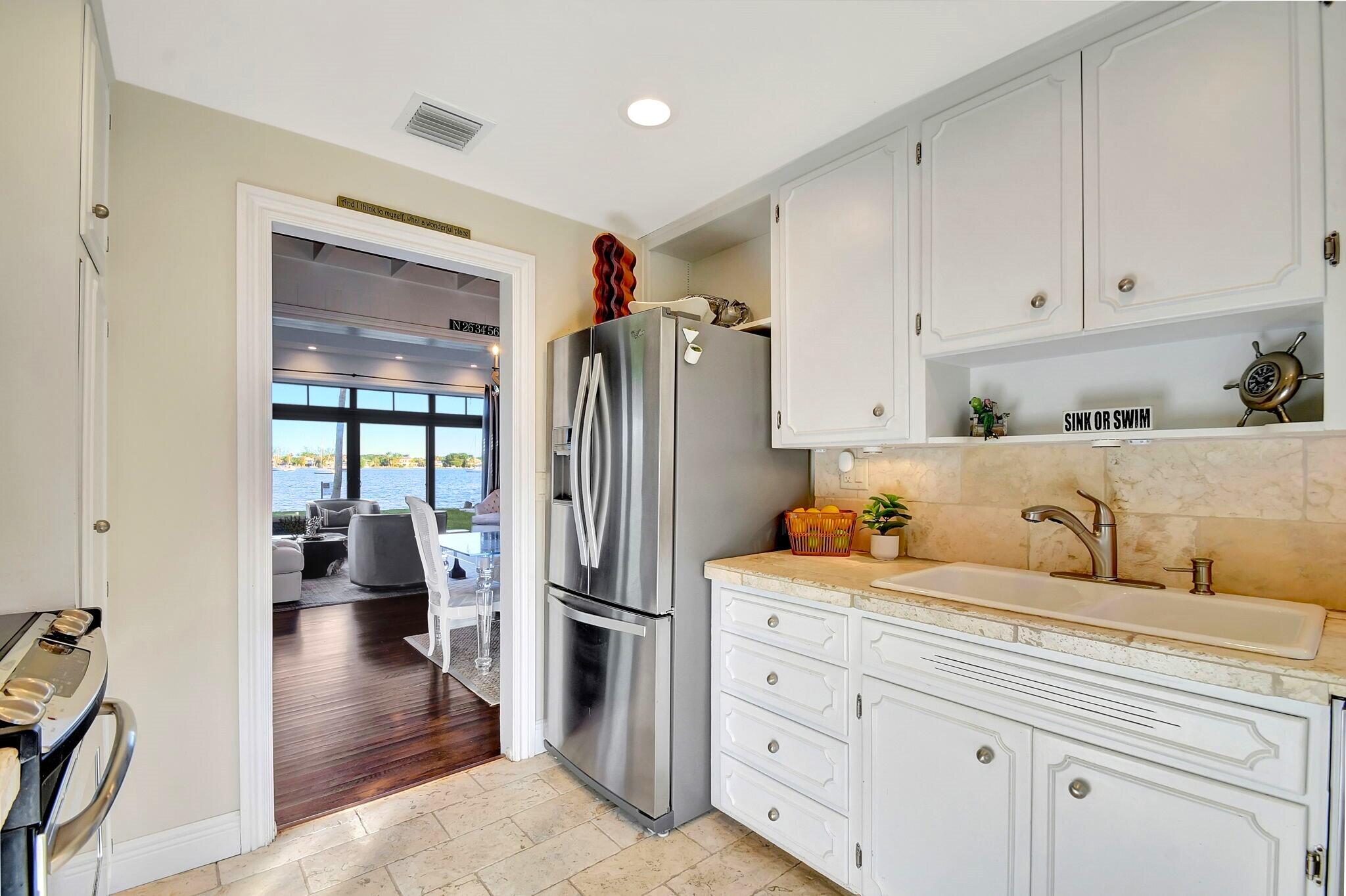 310 South Lake Drive Lantana, FL 33462 - Photo 16 of 65 a kitchen with a refrigerator and white cabinets