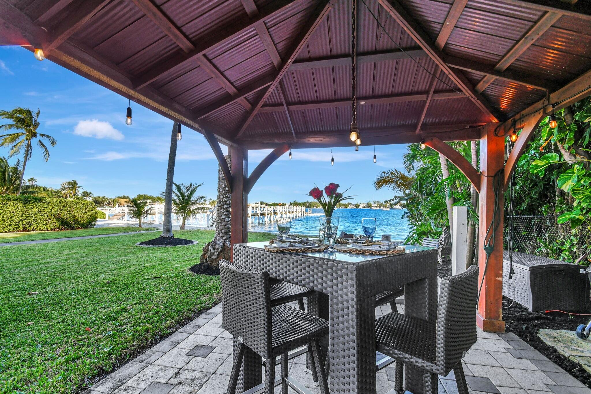 310 South Lake Drive Lantana, FL 33462 - Photo 42 of 65 a patio with a table and chairs under an umbrella