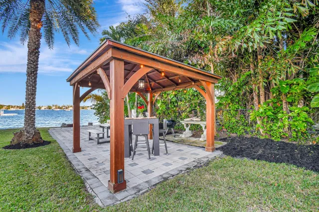 a view of a house with a yard and palm trees