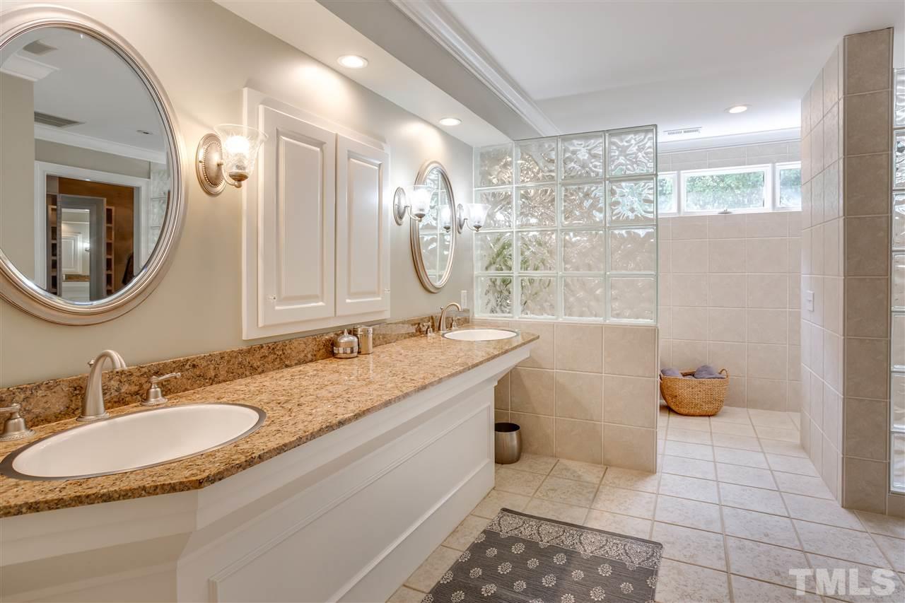 1005 Oak Creek Road Raleigh, NC 27615 - Photo 18 of 30 a bathroom with a granite countertop sink a mirror and a shower