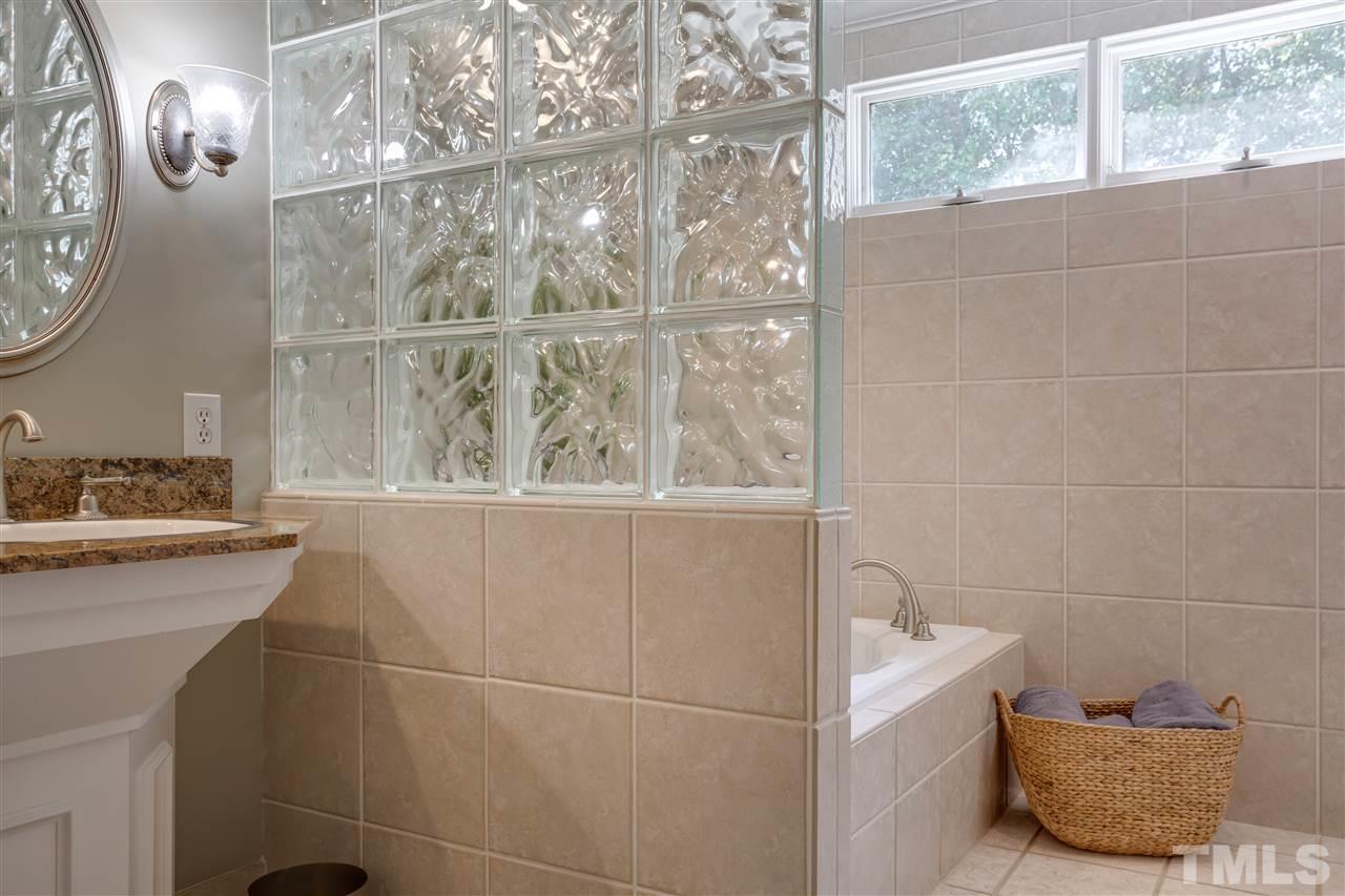 1005 Oak Creek Road Raleigh, NC 27615 - Photo 19 of 30 a bathroom with a tub sink and mirror