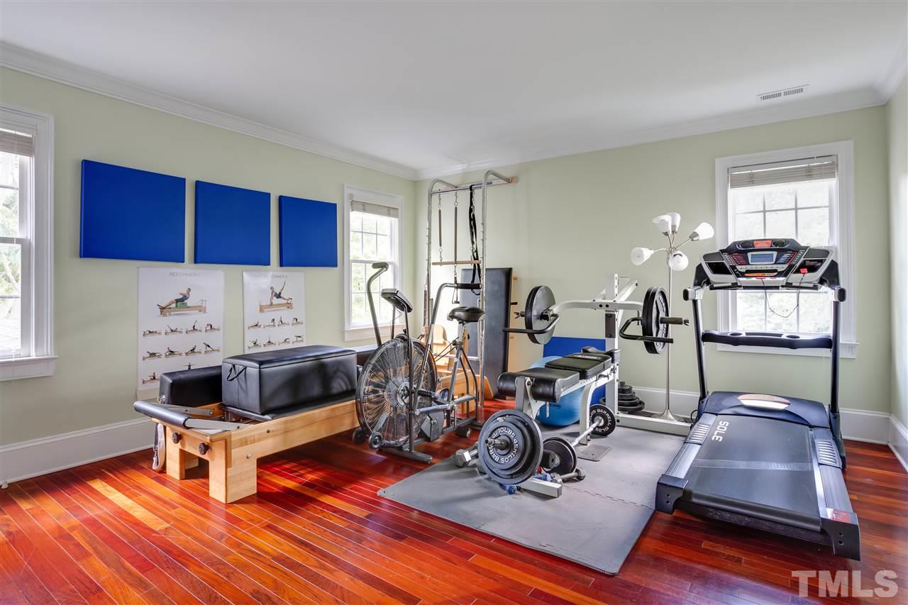 1005 Oak Creek Road Raleigh, NC 27615 - Photo 20 of 30 a living room with furniture a window and gym equipment