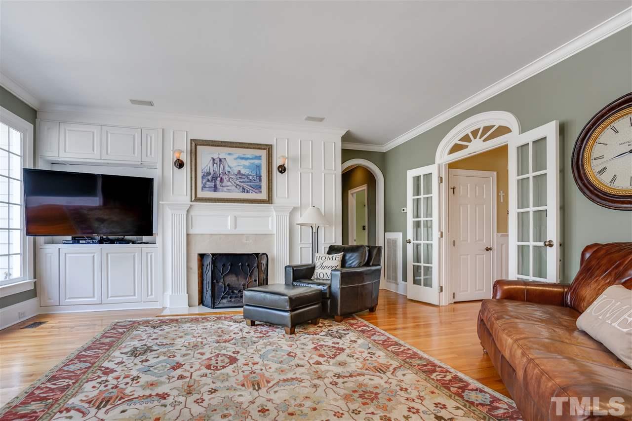 1005 Oak Creek Road Raleigh, NC 27615 - Photo 7 of 30 a living room with furniture a flat screen tv and a fireplace