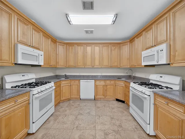 a kitchen with stainless steel appliances granite countertop a stove sink microwave and cabinets