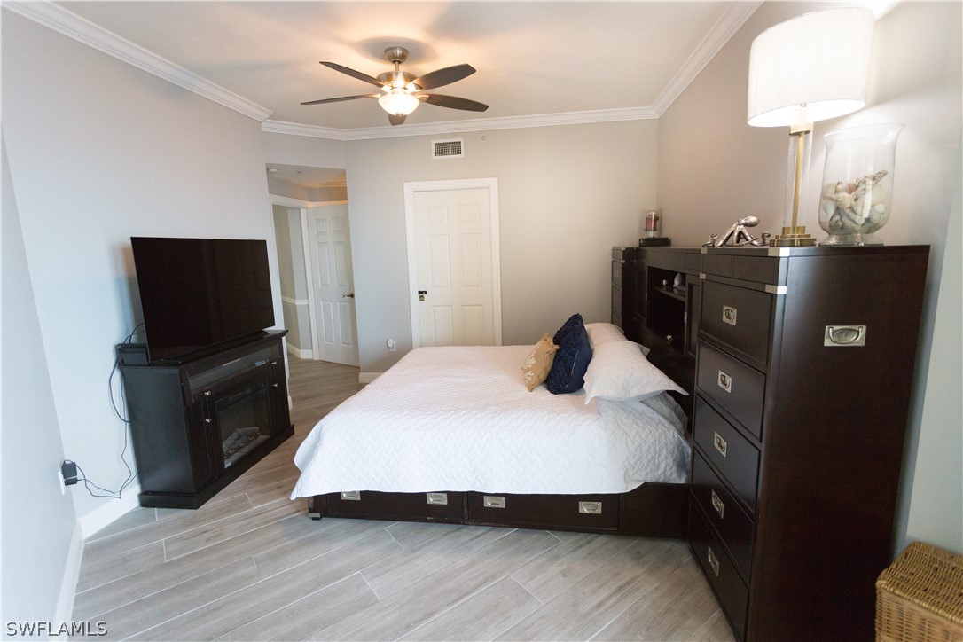 2745 First Street, Unit 1306 Fort Myers, FL 33916 - Photo 14 of 34 a bedroom with a bed and a flat tv screen on a dresser