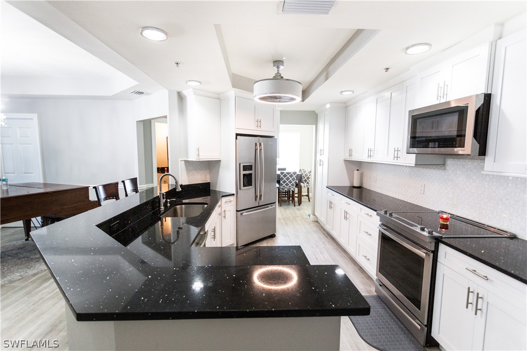 2745 First Street, Unit 1306 Fort Myers, FL 33916 - Photo 19 of 34 a large kitchen with stainless steel appliances granite countertop a sink a stove and a refrigerator