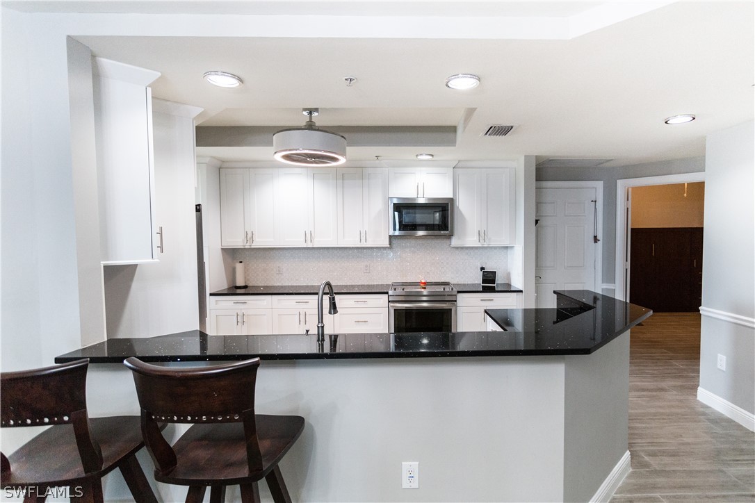 2745 First Street, Unit 1306 Fort Myers, FL 33916 - Photo 20 of 34 a kitchen with stainless steel appliances granite countertop a sink a stove and a refrigerator