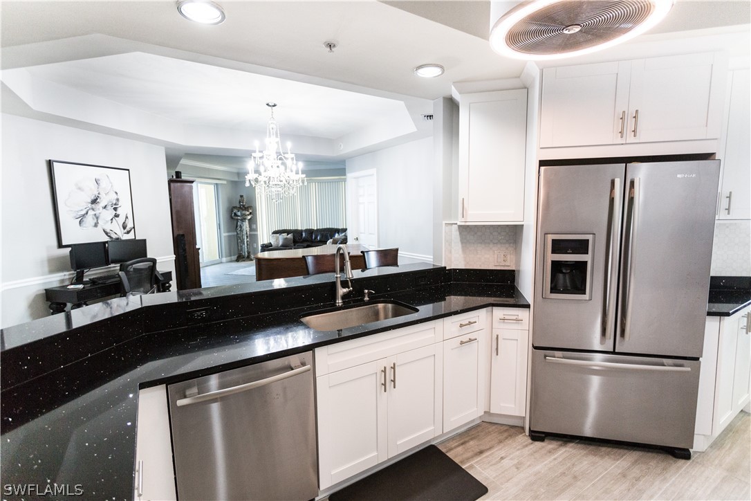 2745 First Street, Unit 1306 Fort Myers, FL 33916 - Photo 21 of 34 a kitchen with stainless steel appliances granite countertop a refrigerator a sink a stove a dining table and chairs